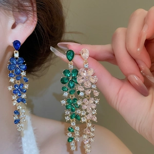 Detail of flower tassel earrings with blue green and pink crystals in gold plating