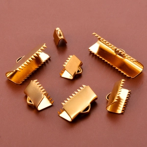 Macro shot of gold stainless steel ribbon crimp ends with teeth for jewelry making
