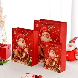 Three sizes of red Christmas Santa gift bags with reindeer print and rope handles