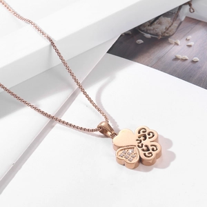 Macro shot of rose gold four-leaf clover pendant with sparkling crystal and hollow details