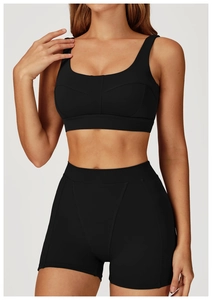 Dettaglio del set yoga nero con reggiseno sportivo e pantaloncini in tessuto elastico