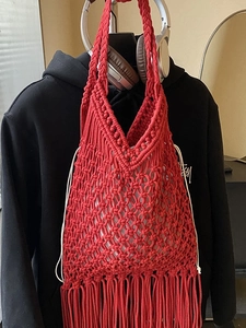Handmade red woven cotton rope tote bag with bohemian fringe detail and drawstring closure