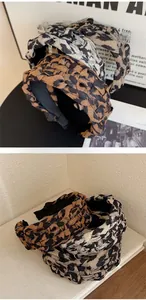Detail of wide braided leopard print headbands in brown, grey, and khaki tones