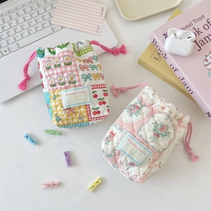 Detailed view of quilted cotton drawstring camera pouches with floral and patchwork patterns