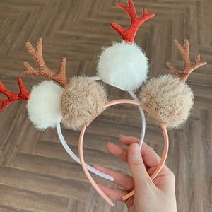 Set of two festive Christmas headbands with glittery reindeer antlers and plush pom-poms