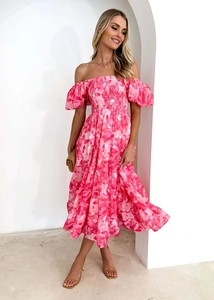 Dettaglio dell'abito floreale con spalle scoperte, vita a punto smock e gonna a balze