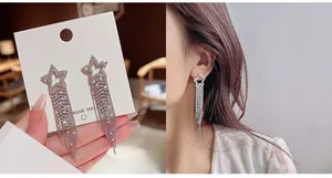 Detail of silver tassel earrings with five-pointed star design and inlaid rhinestones