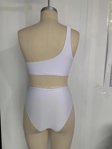 Détail du haut de bikini blanc à une épaule et du bas taille haute à texture côtelée