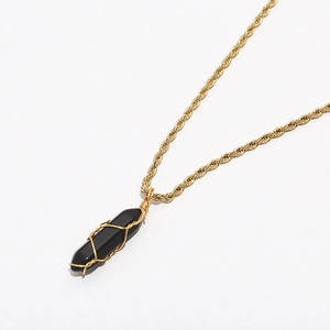 Detail of vintage gold twisted rope chain with wire-wrapped black hexagonal stone pendant