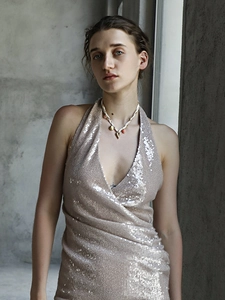 Model draagt een 18K gouden bloemen hanger ketting met rood-wit gevlochten koord