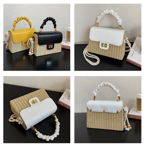 Detail of woven straw box bag featuring leather pleated handle and gold twist lock