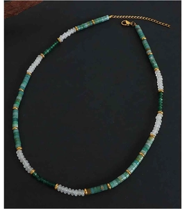 Detail of bohemian handmade necklace featuring green beads and golden metal spacers