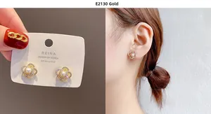 Detail of gold hollow flower earrings with pearl center and S925 silver needle on model