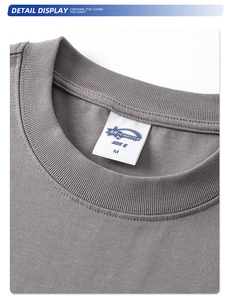 Detalle del cuello de algodón pesado de 325g y la etiqueta de marca en una camiseta gris
