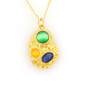 Irregular gold necklace pendant with green, yellow, and blue cat-eye gemstones on white background