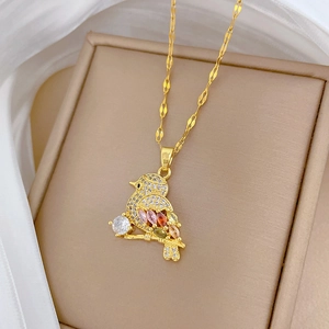Close-up of a gold bird pendant with multi-color zircons in a beige jewelry box