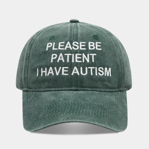 Close-up of white letter embroidery on a washed dark green vintage cotton baseball cap