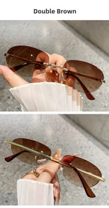 Close-up of rimless oval sunglasses in double brown gradient tint with gold metal temples