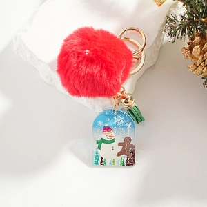 Close-up of Christmas keychain with red pompom, acrylic snowman tag, and green tassel
