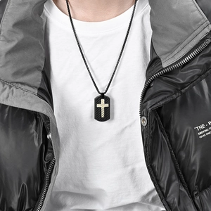 Men's black carbon fiber military tag necklace with a gold cross pendant on a model