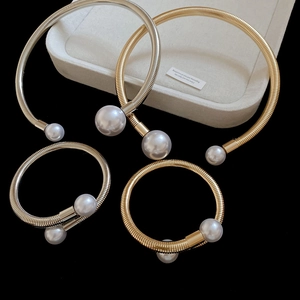Detail of gold and silver choker necklaces and bracelets with large pearls on a display