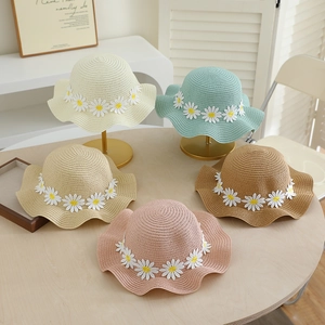 Detail of straw hats for girls featuring daisy flowers and wavy brims in five soft colors