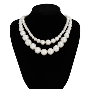 Double-layered pearl necklace with gradient beads displayed on a black velvet bust stand