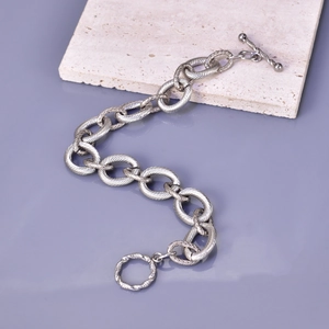 Detailed shot of silver textured chunky chain bracelet featuring a stylish toggle clasp