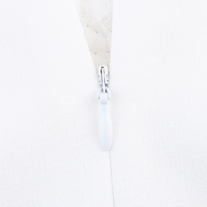 Detailed view of hidden white zipper on princess style puff sleeve dress fabric