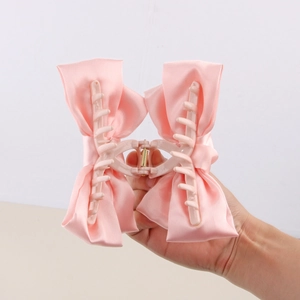 Pince à cheveux rose avec double nœud en satin au design élégant et minimaliste pour femme