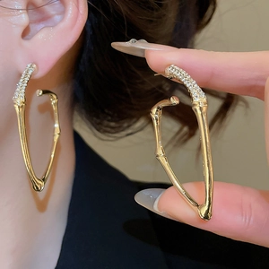 Macro shot of gold bamboo joint earrings featuring intricate crystal pavé detailing