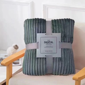 Dark grey-green flannel fleece blanket with striped texture folded on a modern chair