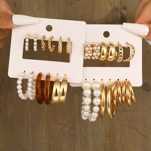 Set of six chunky gold C-shaped hoop earrings with pearls and resin textures