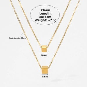Detail of golden cube pendants with Love engraving and chain length specifications