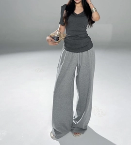 Detail view of a slim fit V-neck grey t-shirt paired with wide leg drawstring joggers