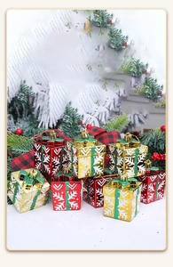 Close-up of red and gold Christmas gift box ornaments with snowflake patterns and glitter bows
