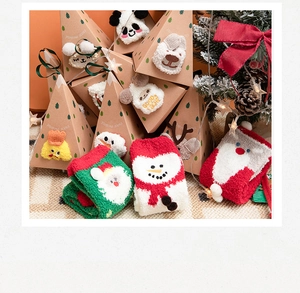 Detailed view of plush Christmas socks with festive patterns in triangular gift boxes