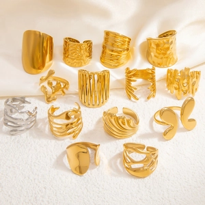 Flat lay view of 18k gold and silver stainless steel rings with textured finishes