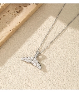 Macro view of S925 silver mermaid tail pendant featuring white pearls and tiny crystals