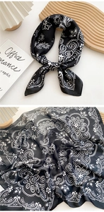 Close-up of black and white paisley pattern silk scarf with elegant drape and texture