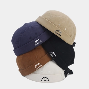 Vertical stack of five colorful miki hats showing detailed peak embroidery and canvas texture