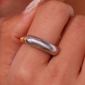 Macro detail of minimalist two-tone silver and gold plated titanium steel smile ring