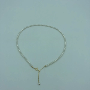 Detail of white round pearl necklace with 14k gold-filled lobster clasp and extender chain