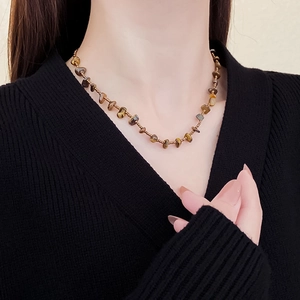 Detail of vintage Maillard brown tiger eye bead necklace worn on a person's neck