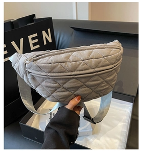 Detailed view of grey quilted crossbody bag with diamond stitching and metal zipper