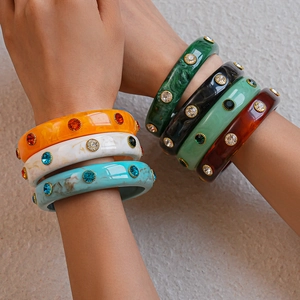 Close-up of colorful marble acrylic bangles featuring sparkling inlaid rhinestones