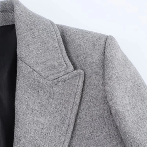 Macro shot showing the gray wool blend texture and twill weave detail of the coat collar