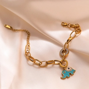 Detailed shot of golden elephant pendant with teal enamel and zircons on thick chain bracelet