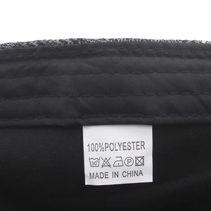Detail of grey plaid beret showing the inner lining and polyester material care label
