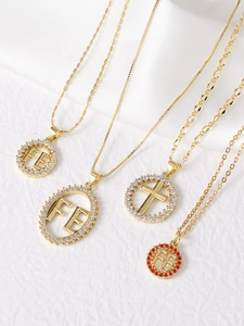 Detailed view of gold plated necklaces with FE faith letters and cross zircon pendants